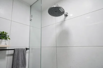 Pommeau de douche à faible consommation d'eau monté au mur dans une salle de bain moderne minimaliste