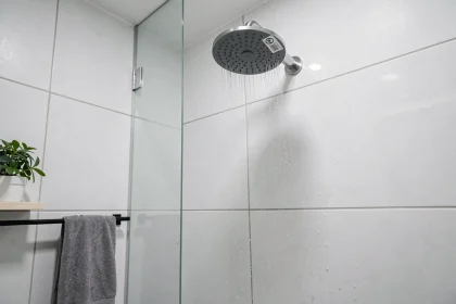 Pommeau de douche à faible consommation d'eau monté au mur dans une salle de bain moderne minimaliste